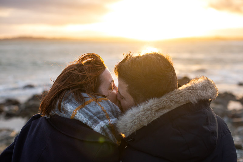 couple qui s'embrasse au bord de la mer coucher de soleil