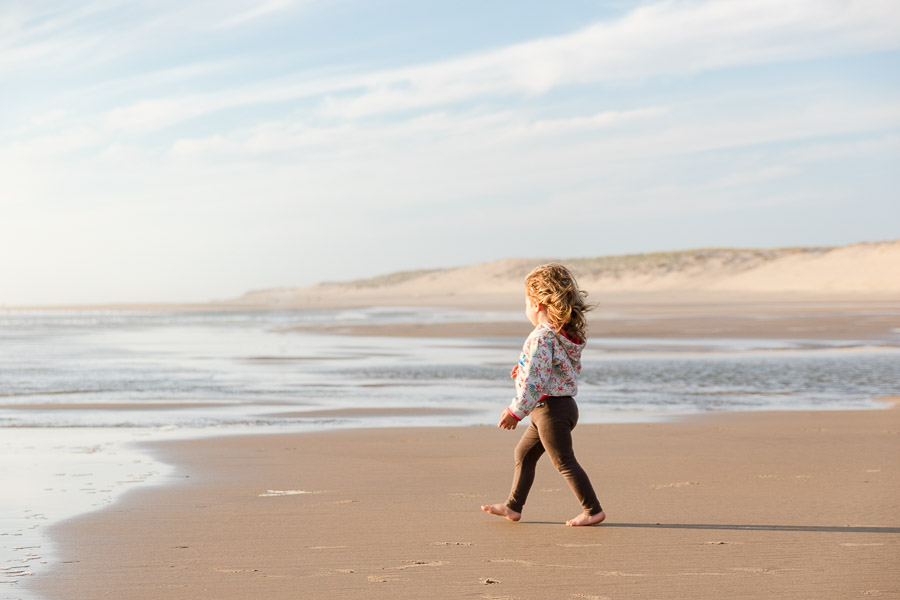 photo d'une enfant sur la plage, cheveux dans le vent