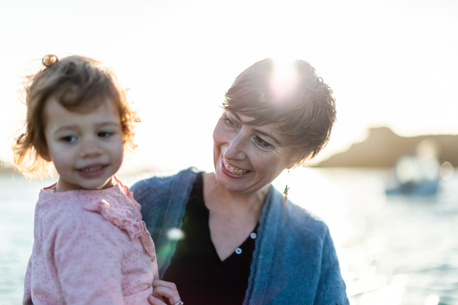 petite fille dans les bras de sa maman sur la plage Coz pors trégastel cote de granit rose