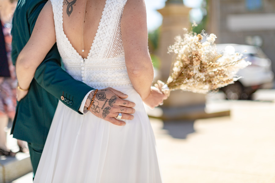 mains tatoué du marié qui enlace la mariée