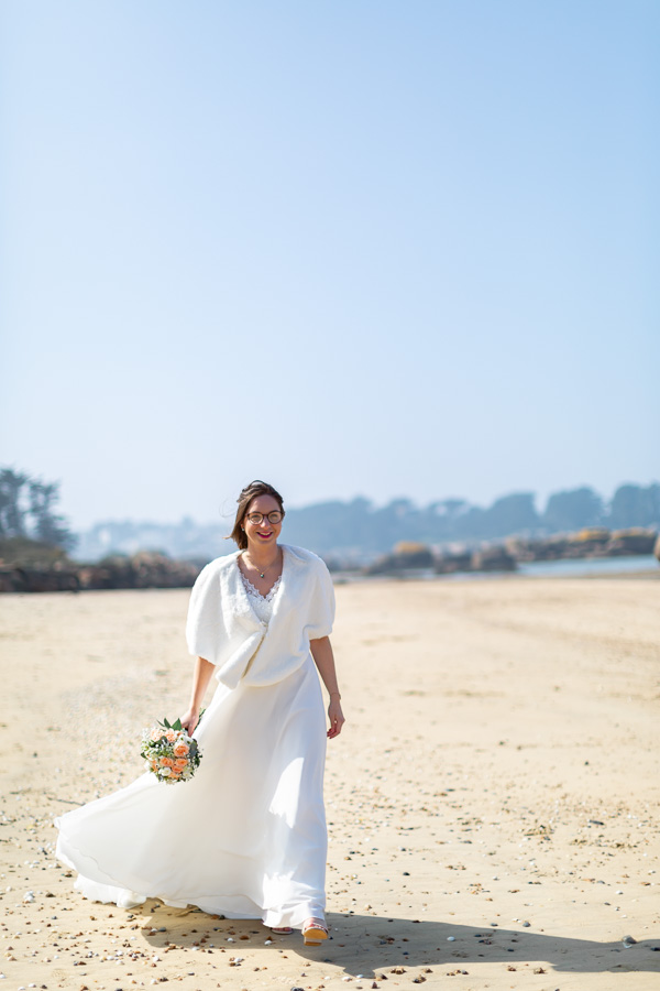 mariée qui marche sur la plage de Sainte-Anne Trégastel