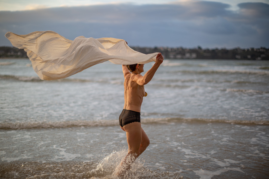 Cancer du sein séance photo portrait de femme en extérieur plage courir dans l'eau