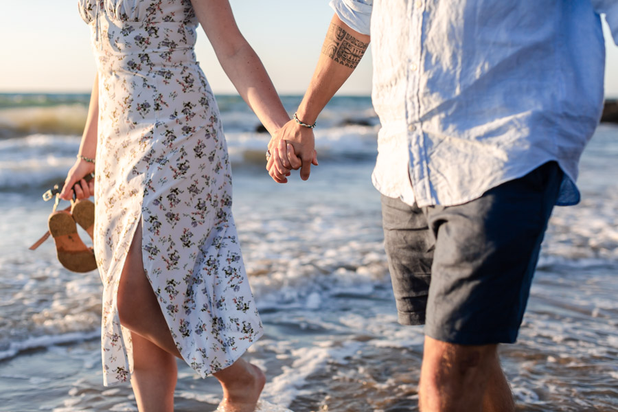 couple marche mains dans la main à la plage