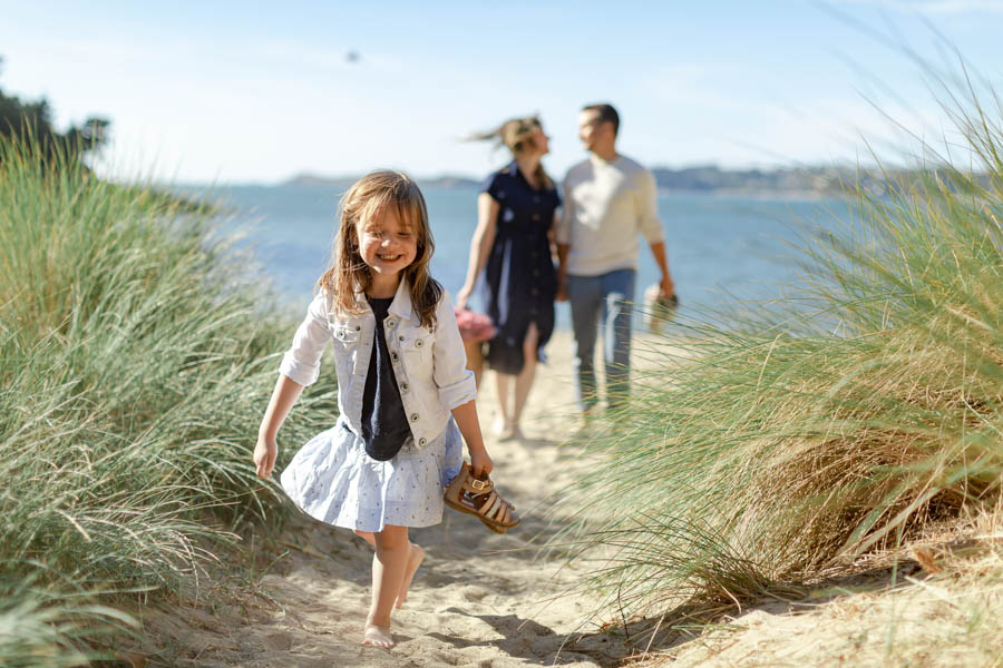 photo fillette marchant devant ses parents à la plage
