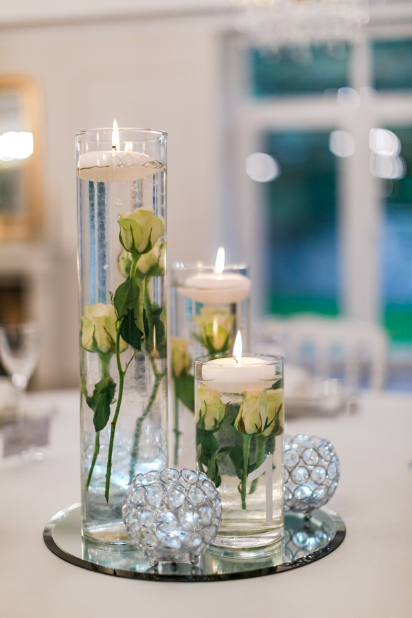 Décoration de table mariage rose blanche immergée dans vase cylindrique bougie et diamant