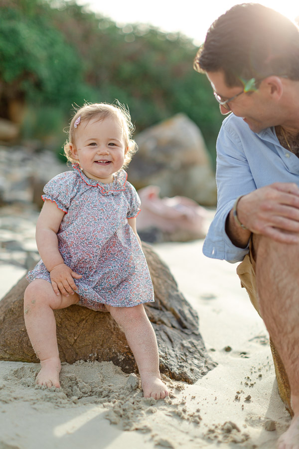 petite fille souriante à la plage avec son papa
