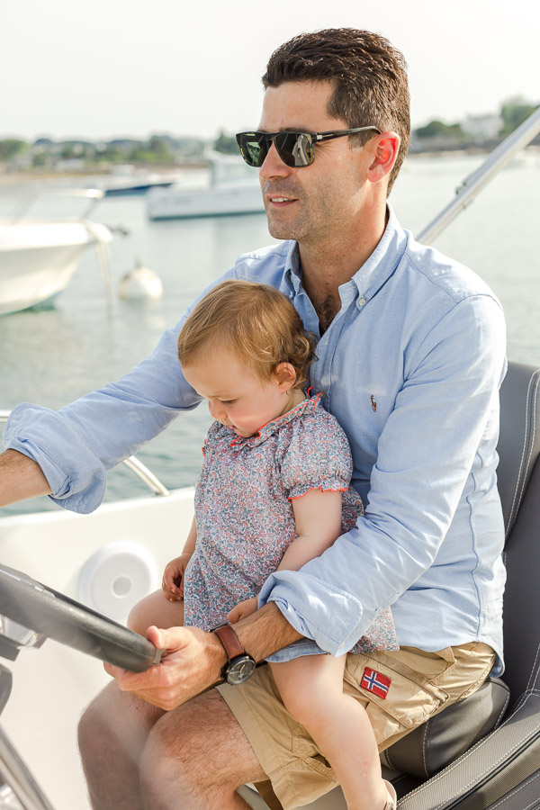 bébé sur les genoux de son papa dans le bateau