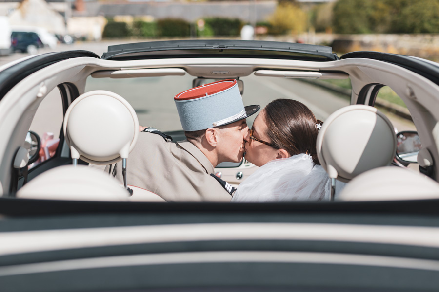 photo de couple de mariés qui s'embrassent la voiture