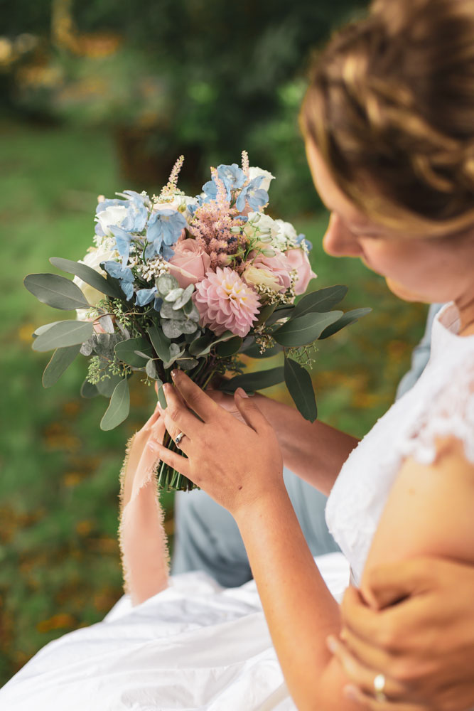 Photos du bouquet de la mariée bleu et rose pastel délicat porté par la mariée