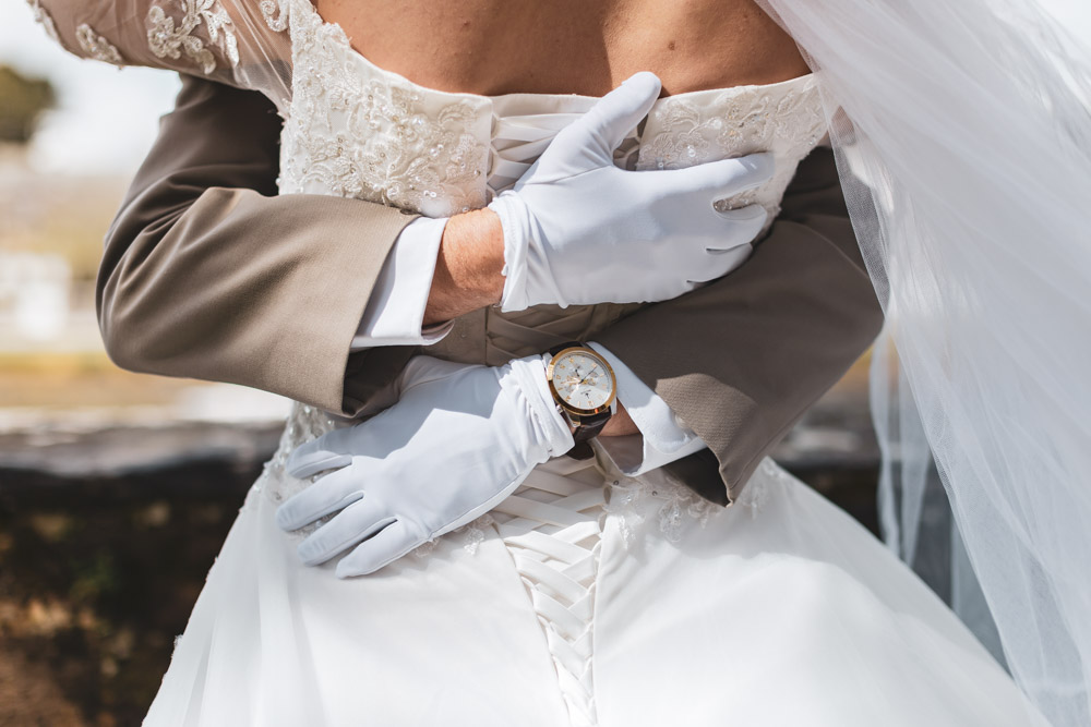 Couple de mariés enlacés. Gant montre et lassage de robe. Le Faou