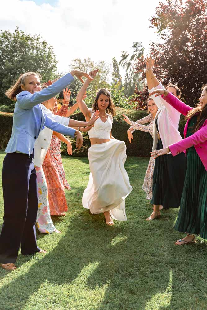 Photo de groupe fun et joyeuse - Haie d'honneur la mariée danse au milieu des copines - Vin d'honneur Mariage