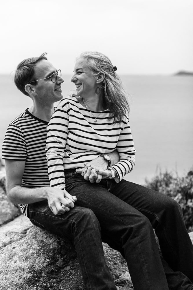 seance photo - couple joyeux assis dans les rochers - Dourven Tredrez Locquémeau