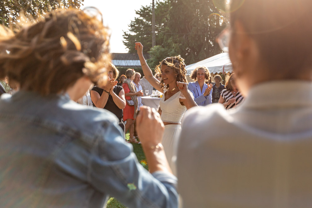 Photo de groupe fun et joyeuse - la mariée danse au milieu des invités - Vin d'honneur Mariage
