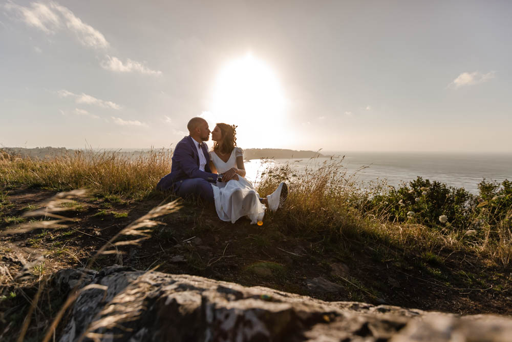 Photo de couple romantique en haut du Grand rocher coucher de soleil - Baie de saint michel en greve - Mariage