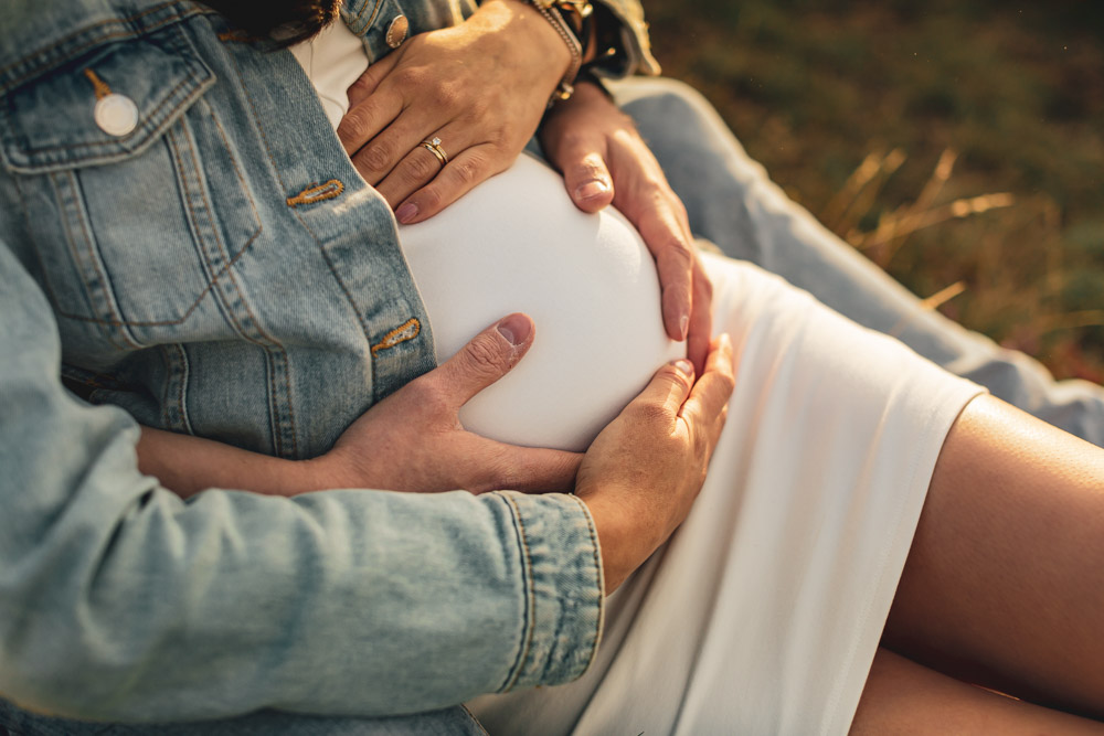 Photo de couple grossesse mains sur le ventre ploumanach coucher de soleil - Perros-guirec