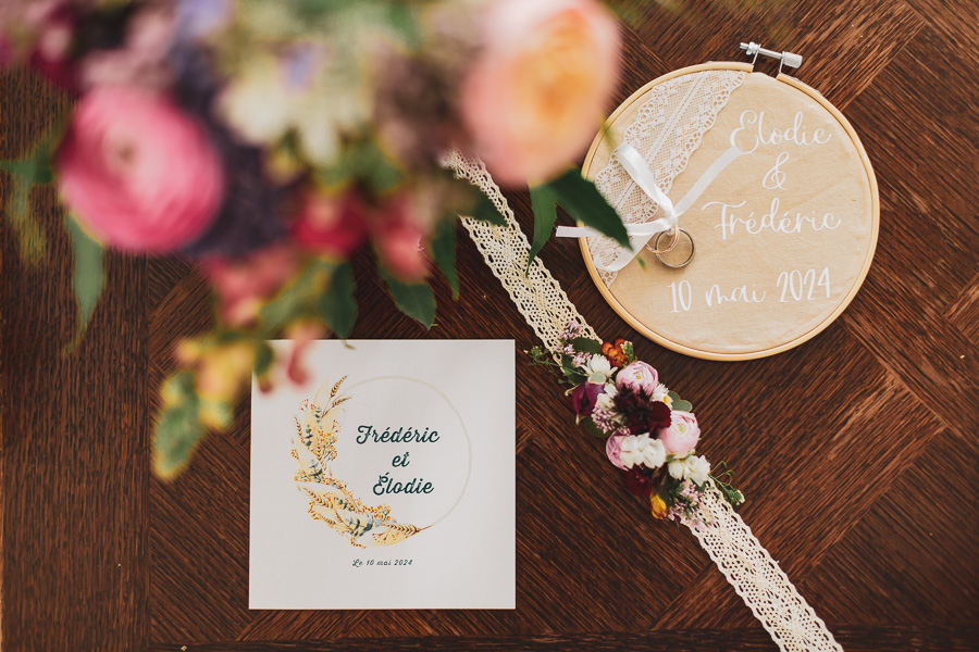 photos des alliances, du bouquet et du faire-part sur une table en bois
