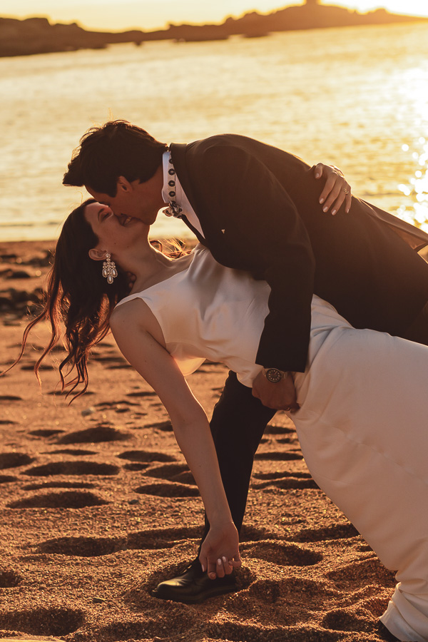 Les mariés enlacés et amoureux au coucher du soleil sur la plage de l'ile Renote