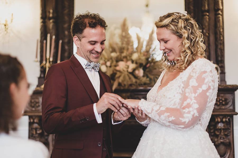 échange des alliance lors de la cérémonie laique au chateau de kerezellec, costume du marié rouge bordeaux