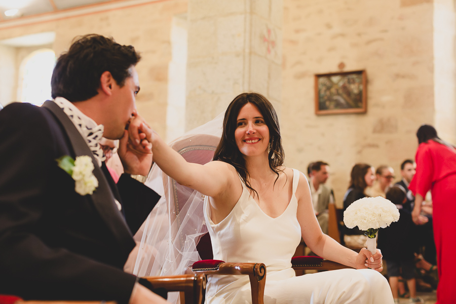 bisous du marié sur la main de la mariée lors de la cérémonie religieuse