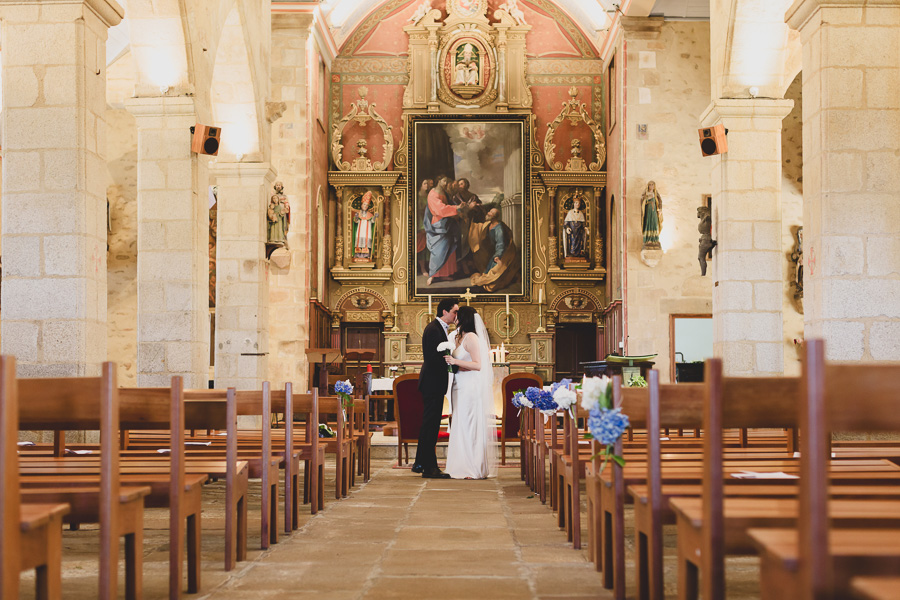 les mariés s'embrassent dans l'allée de l'église, romantique