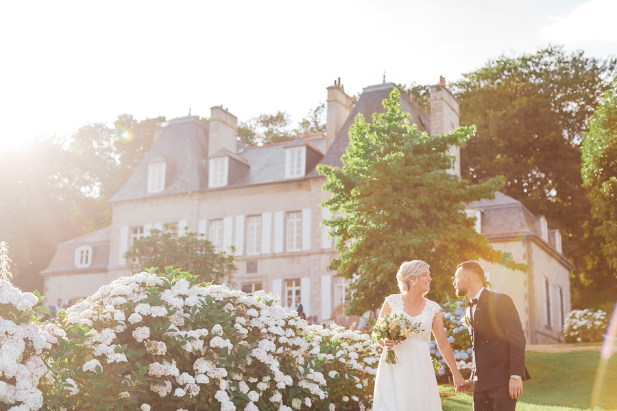 Les mariés complices au chateau de Kerezellec avec les hortensias et le soleil du soir