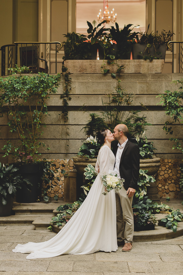 les mariés qui s'embrassent dans le jardin d'hiver de la mairie de Brest, romantique