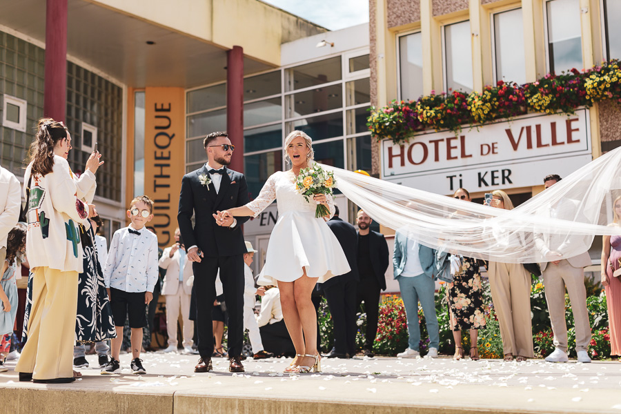 la mariée voyant sa surprise devant la mairie de Guilers, son voile volant dans les airs
