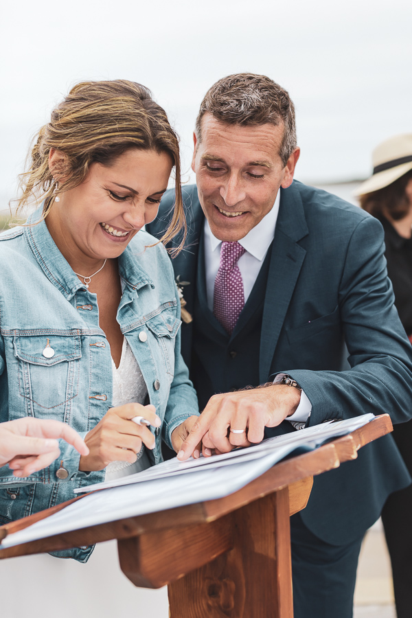 les mariés qui rigolent ensemble lors de la signature