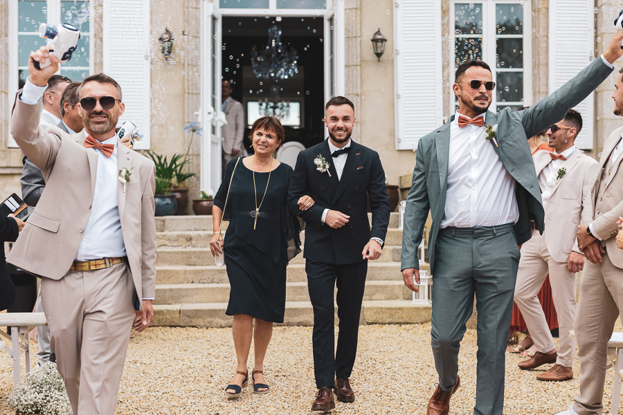 entrée du marié avec sa maman et ses garcons d'honneur qui font des bulles devant le chateau de kerezellec