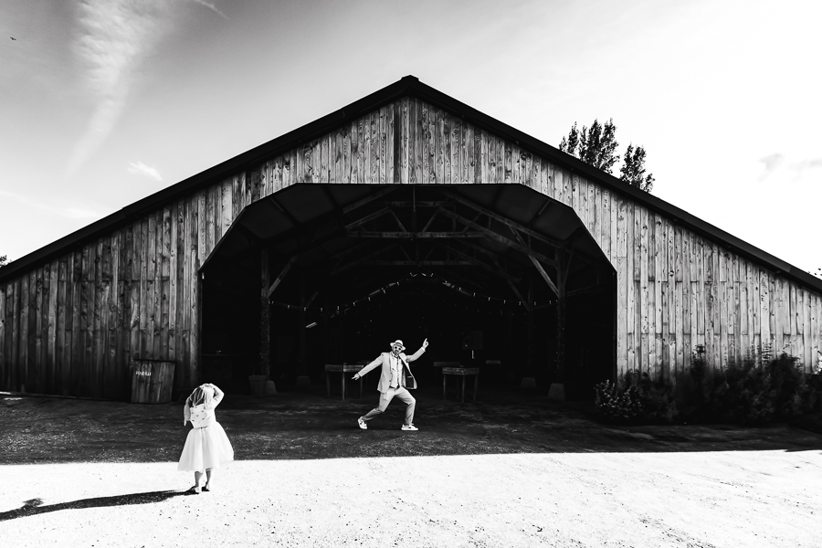Photo fun du marié en noir et blanc devant la grange de La Grande Vadrouille à Plestin Les grèves