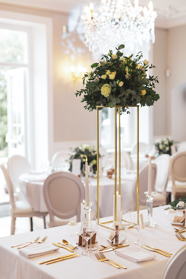 Décoration de table chic et élégant avec des fleurs blanches et des couverts dorés