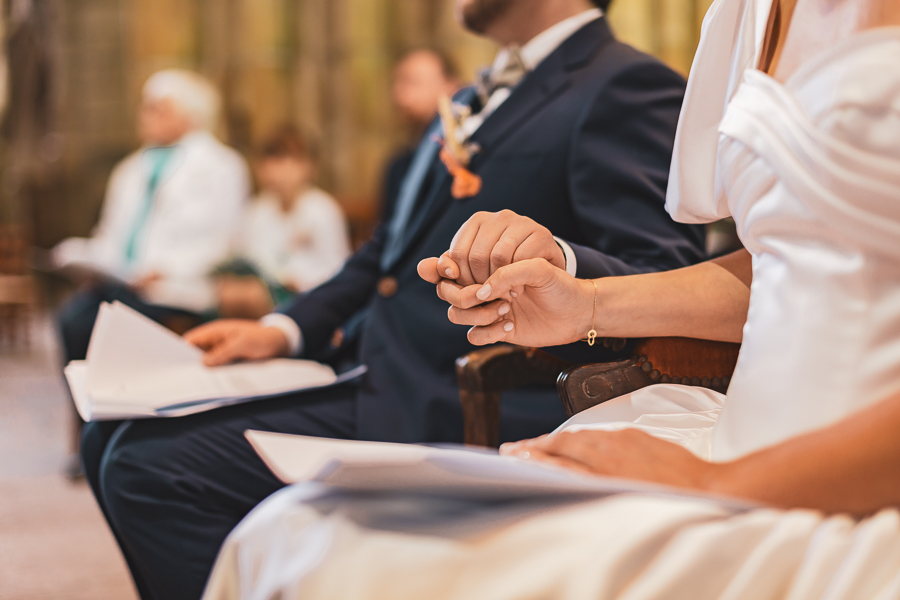 les mariés se tiennent la main lors de la cérémonie religieuse