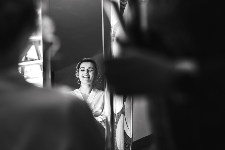 préparatifs de la mariée souriante, reflet dans le miroir en noir et blanc