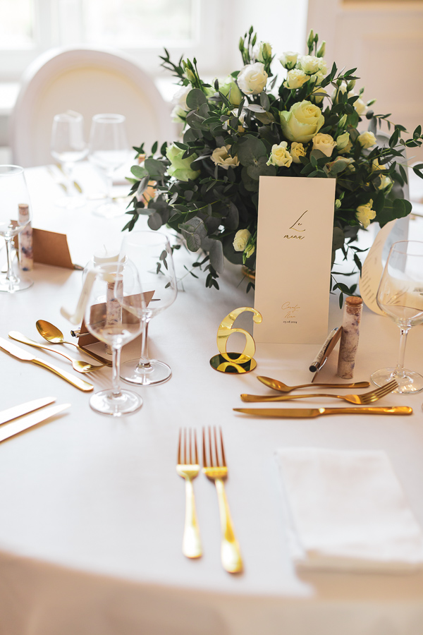 Décoration de table chic et élégant avec des fleurs blanches et des couverts dorés