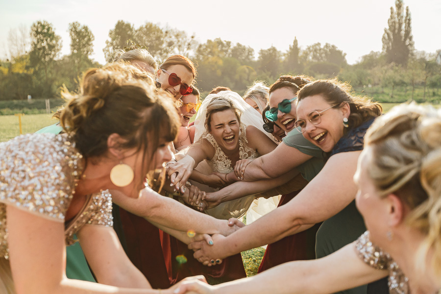 photos de groupe fun et rigolote où la mariée saute au milieu de ses amies
