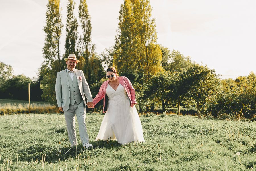 Les mariés se baladent dans le vergers au coucher de soleil à la Grange Vadrouille, Plestin Les greves