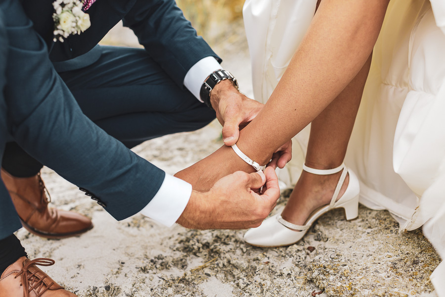 le mariés aide la mariée à mettre ses chaussures