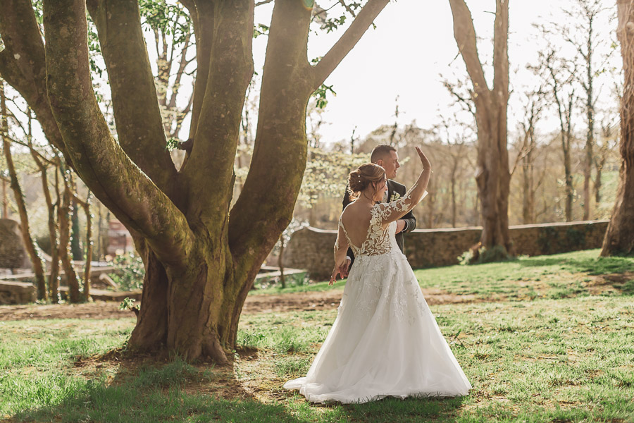 Les mariés saluent des proches dans le jardin du Manoir de Kerleguer lors du coucher de soleil