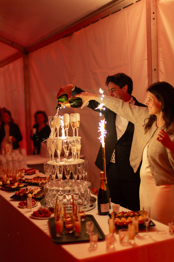 Les mariés servent les flutes de la fontaine de champagne en rigolant et en complicité. Trégastel