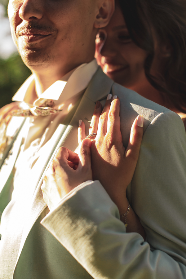 Mains des mariés enlacés dans la lumière du soleil du soir