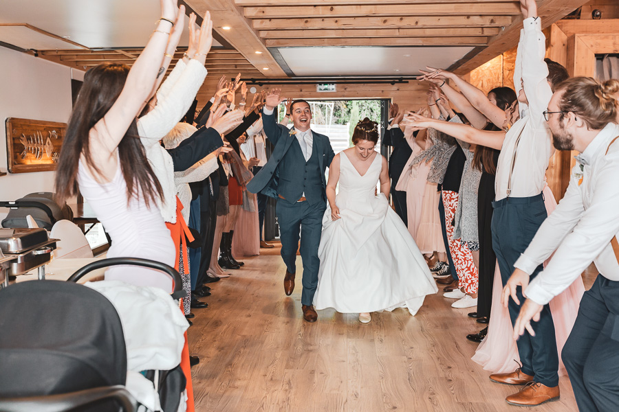 entrée des mariés dans la salle de réception avec une haie d'honneur des invités. Joie et rire. Salles Les Terrasses du Val à Pléneuf Val André