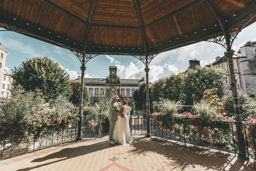 Les mariés enlacés se regardent dans le kiosque de Morlaix, devant la mairie. Romantisme