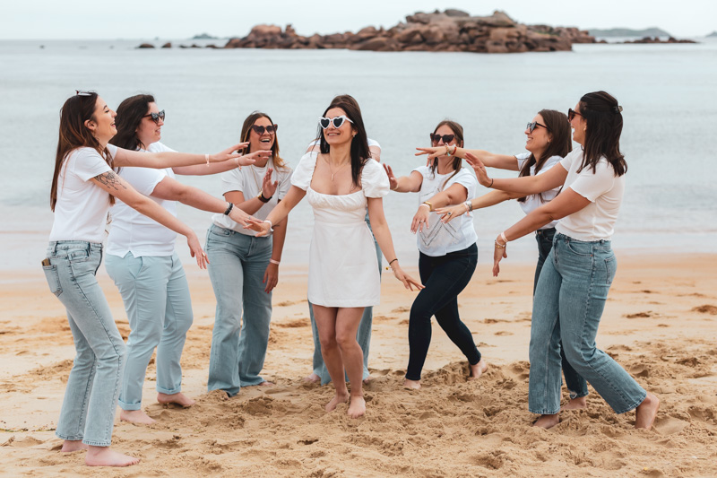 les filles sont autour de la future mariée et elles s'amusent à danser sur la plage a tregastel