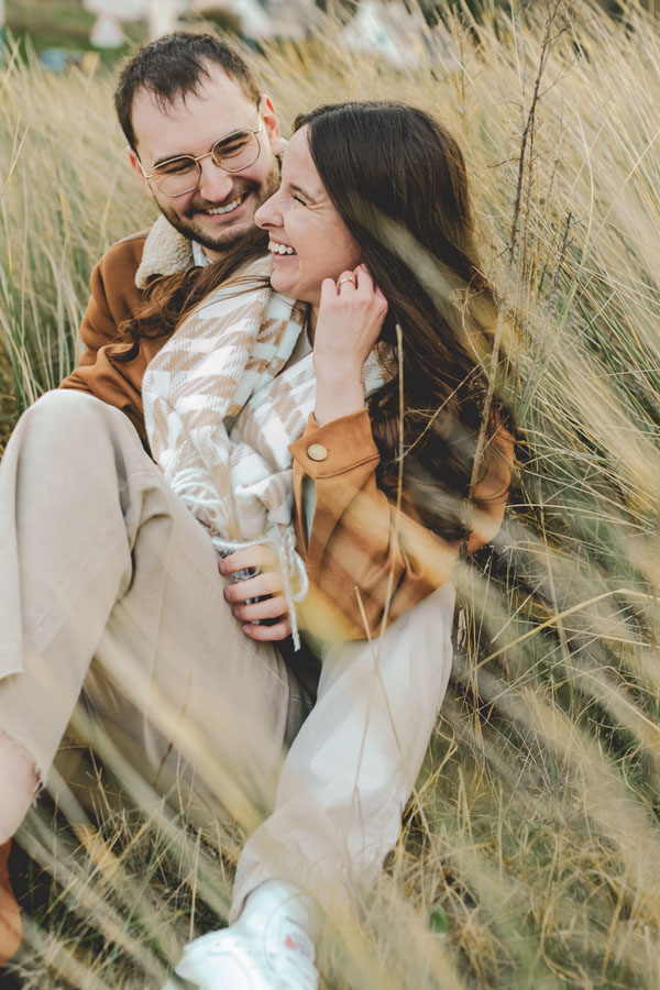 couple assis dans les dunes, tendresse et complicité pendant la seance photo