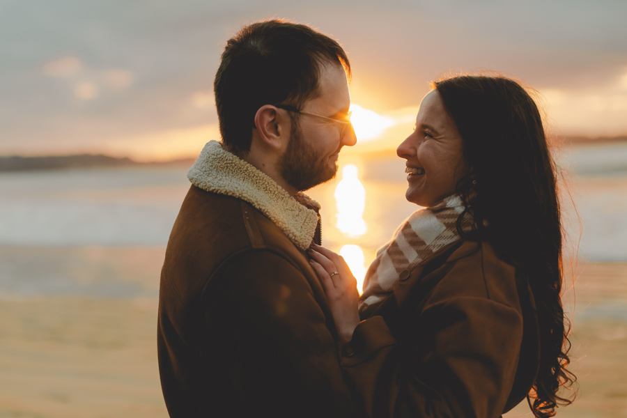 couple se regardent, amoureux et complice devant le coucher de soleil