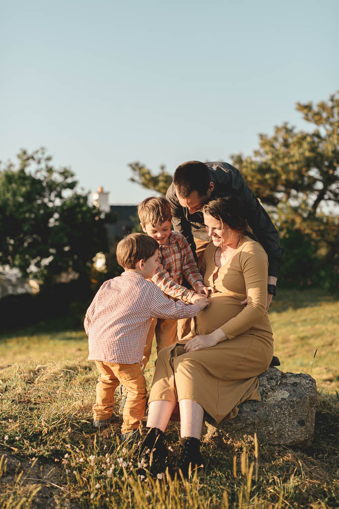 moment en famille ou ils posent tous leurs mains sur le ventre grossesse
