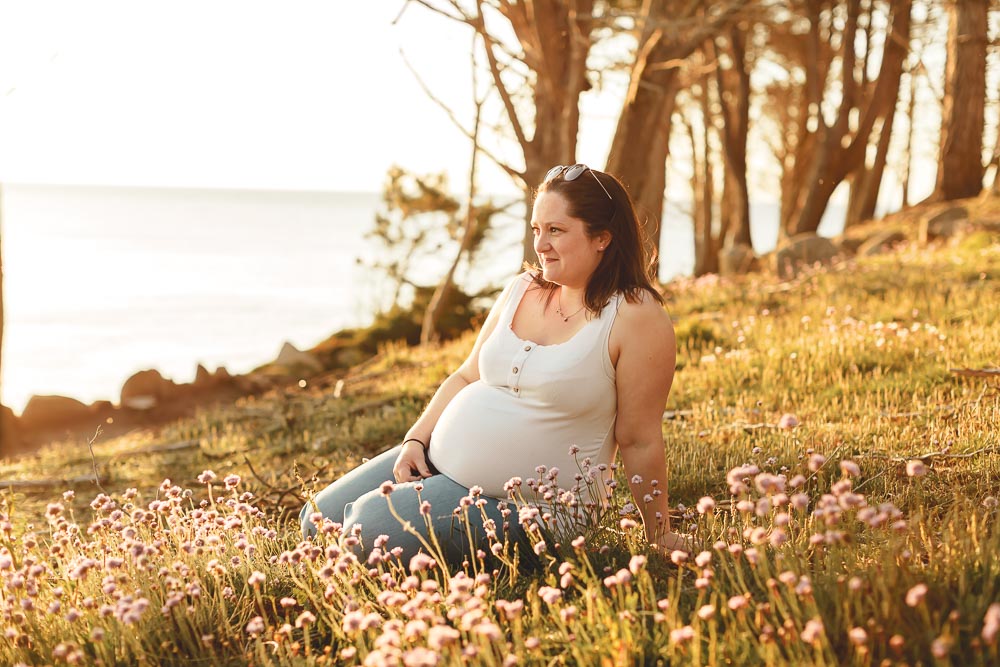 lumiere dorée seance photo grossesse femme enceinte dans les fleurs au bord de mer