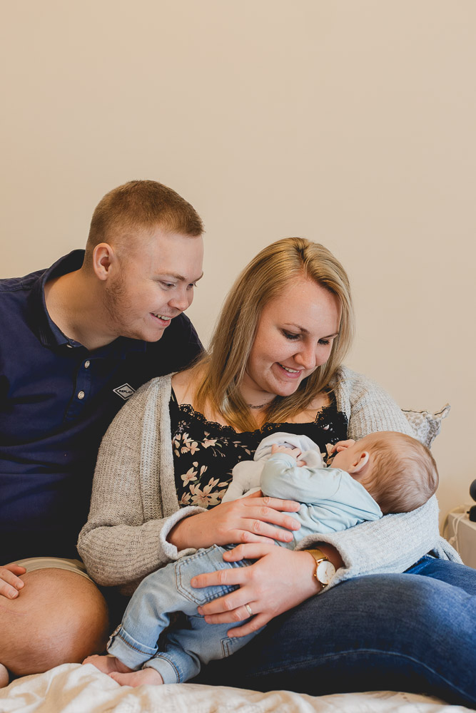 bébé avec ses parents sur le lit moment de complicité et de calin