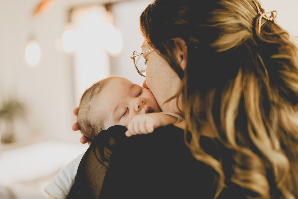 bebe qui dort dans les bras de sa maman tendresse
