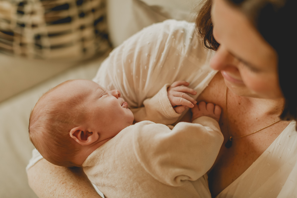 bébé dort dans les bras de sa maman